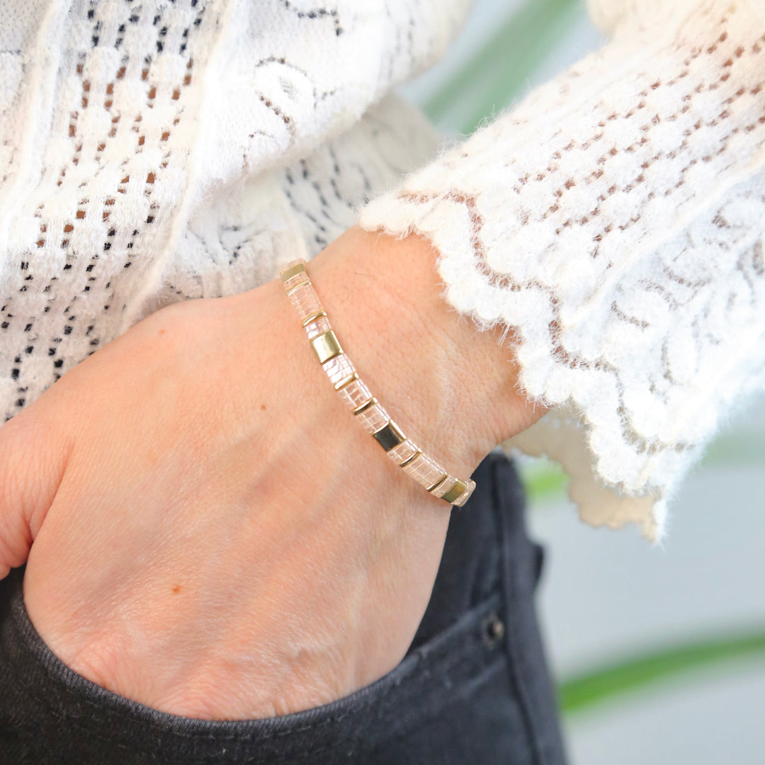 a close up of a person wearing a gold bracelet