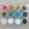 a bunch of different colors of beads in plastic containers
