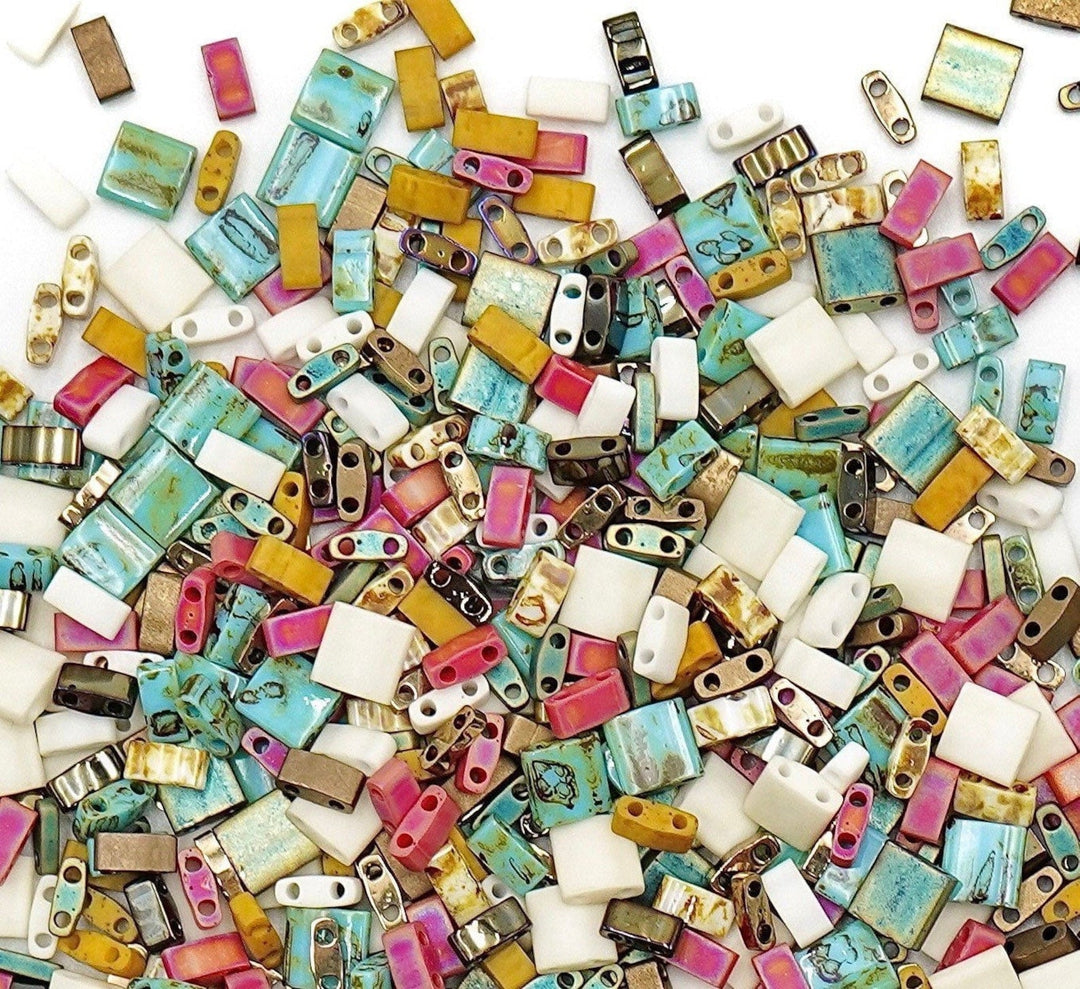 a pile of assorted colored beads on a white surface