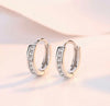 a pair of diamond hoop earrings on a white background