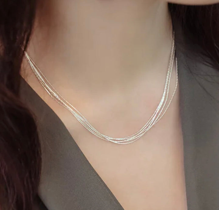 a close up of a woman wearing a necklace