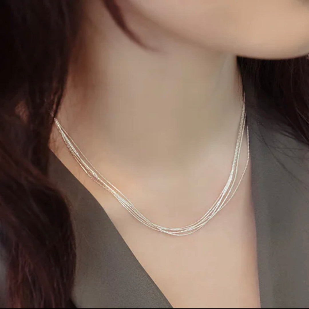 a close up of a woman wearing a necklace