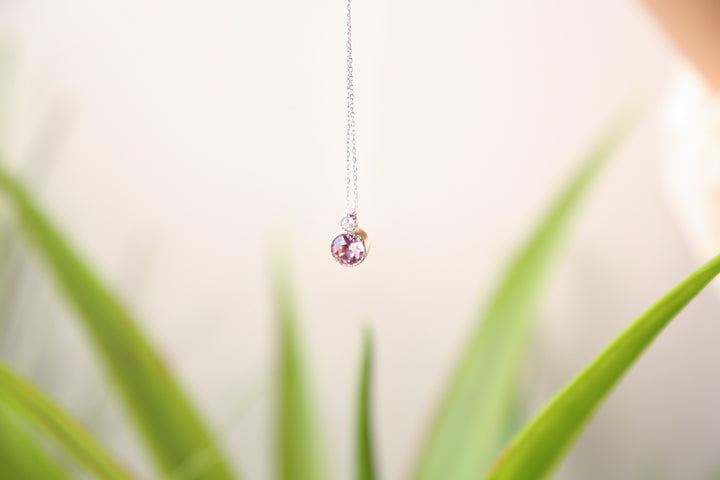a close up of a plant with a necklace on it