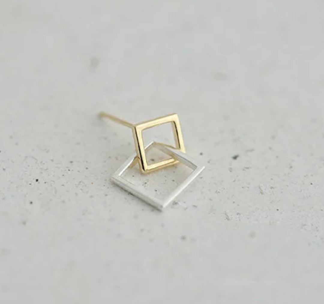 a pair of gold earrings with a square shaped design