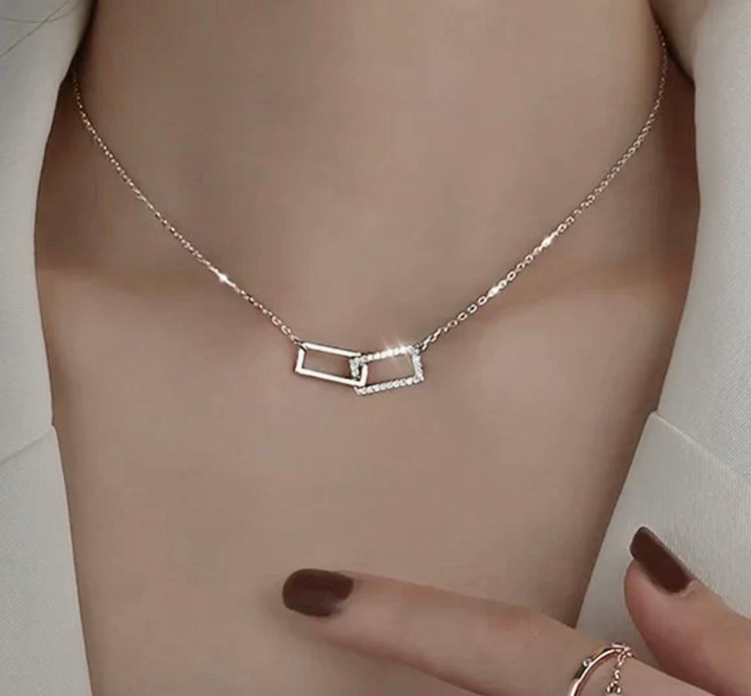 a close up of a person wearing a necklace and ring