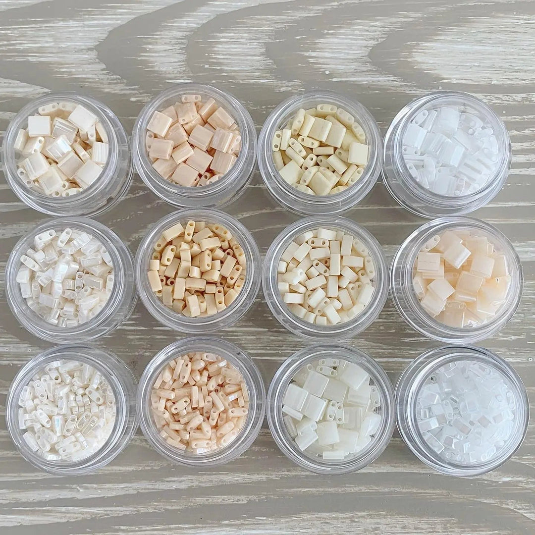 a group of small containers filled with different colored beads