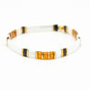 a white bracelet with yellow and brown beads