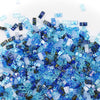 a pile of blue glass cubes sitting on top of a table