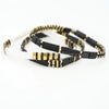 a couple of black and gold bracelets on a white background