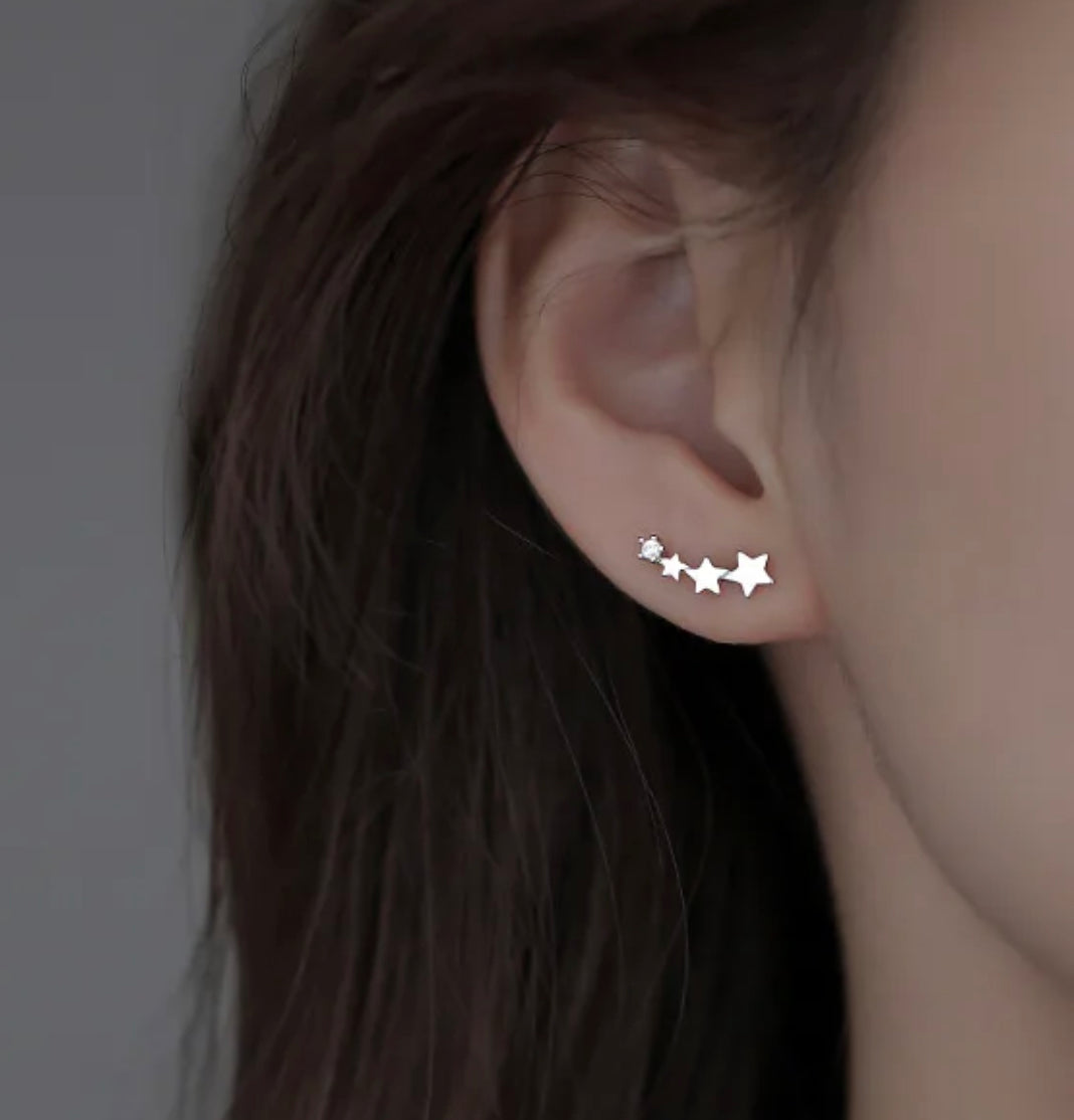 a woman's ear with three stars on it