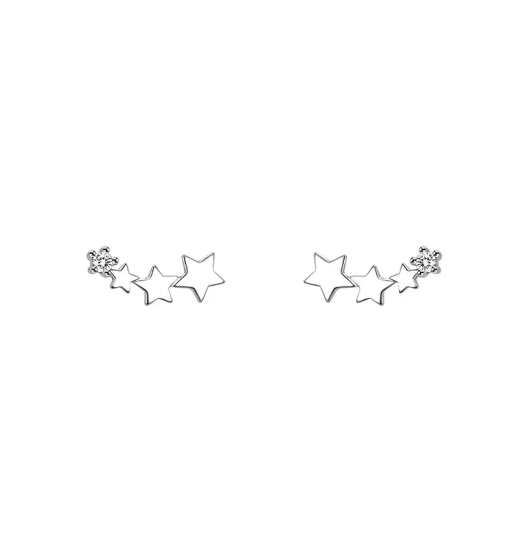 a pair of star shaped earrings on a white background