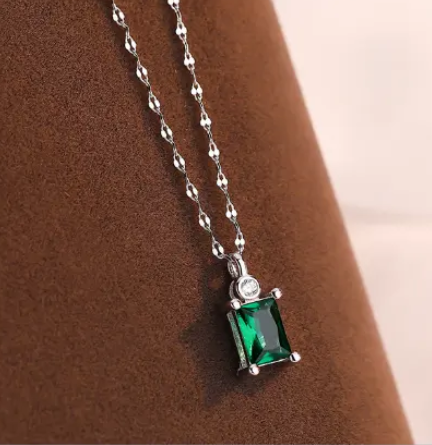 a necklace with a green stone hanging from it