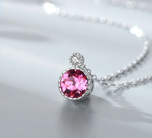 a necklace with a pink stone on it