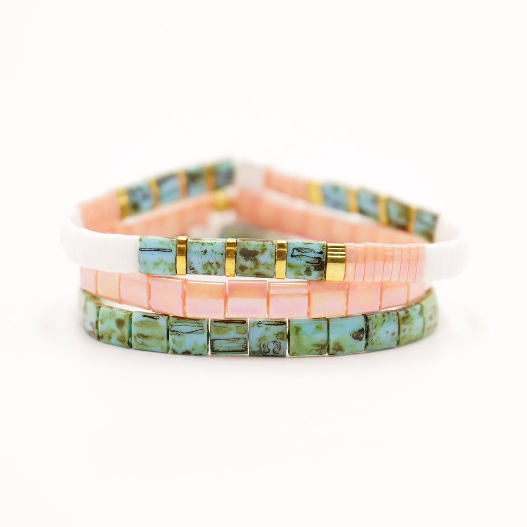 a stack of three bracelets with turquoise and pink beads