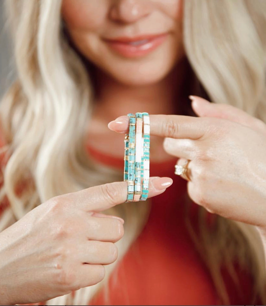 a woman wearing a ring with a turquoise and white pattern on it