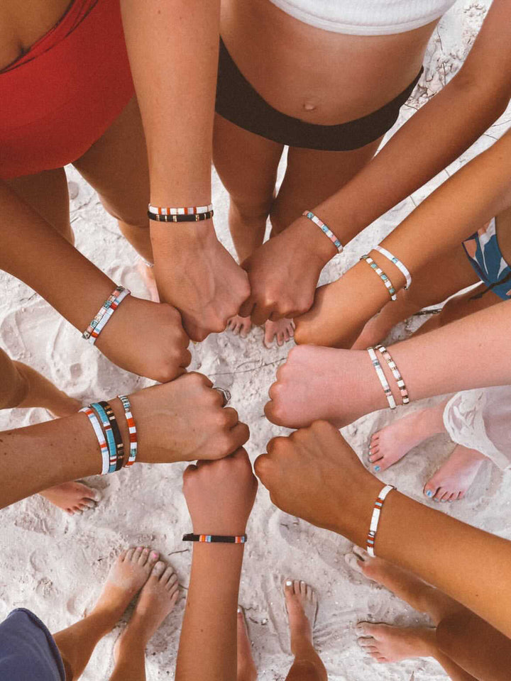 a group of people standing in a circle with their hands together