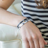 a woman sitting on a couch wearing a bracelet