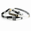 three black and white bracelets with gold accents