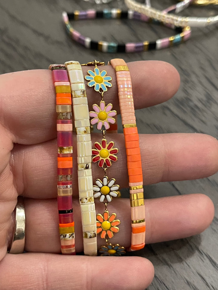 a person holding a bunch of bracelets in their hand