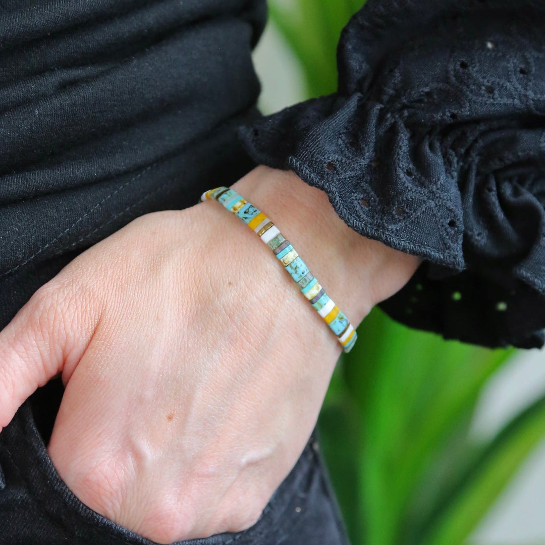a woman's hand wearing a bracelet with a beaded design