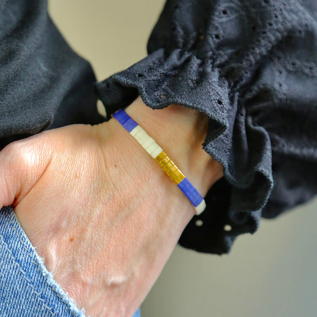a person wearing a blue and yellow bracelet