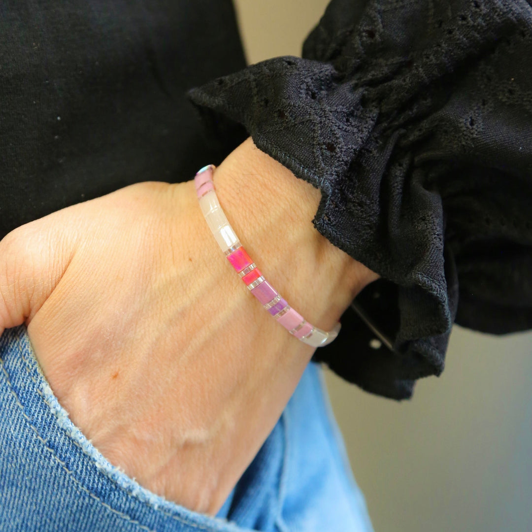 a woman wearing a pink and white bracelet