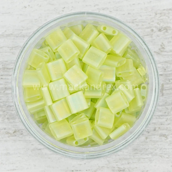 a bowl filled with yellow plastic beads on top of a wooden table