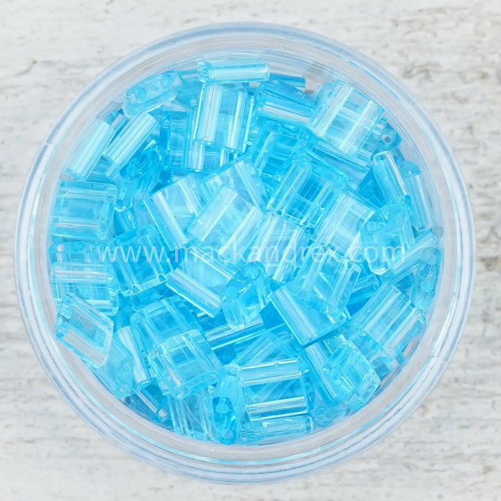 a bowl filled with blue beads on top of a table