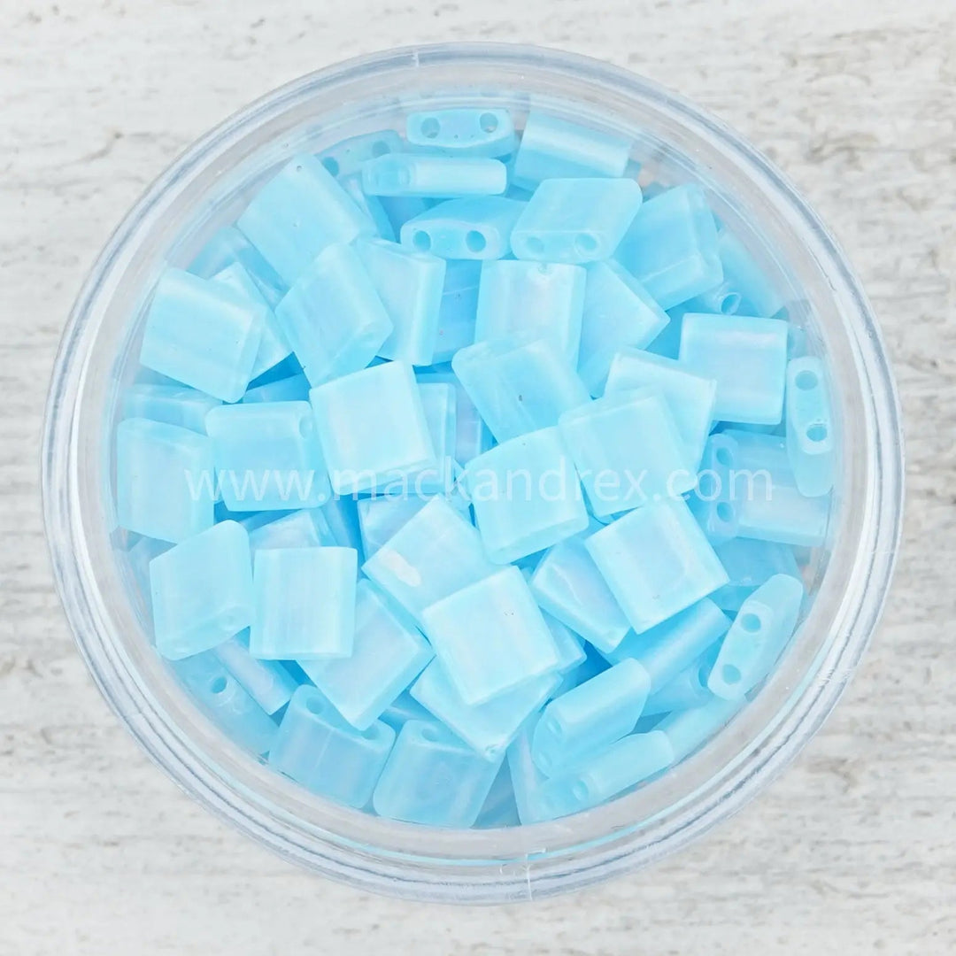 a bowl filled with blue plastic beads on top of a wooden table