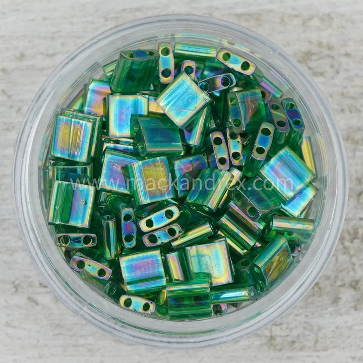 a bowl filled with green and yellow glass beads