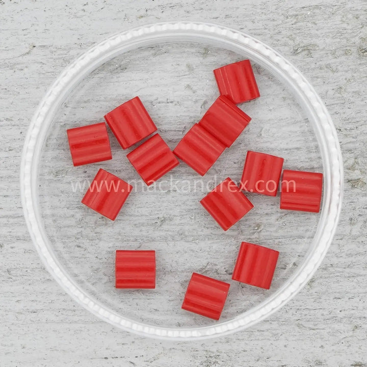 a plastic bowl filled with red squares on top of a table