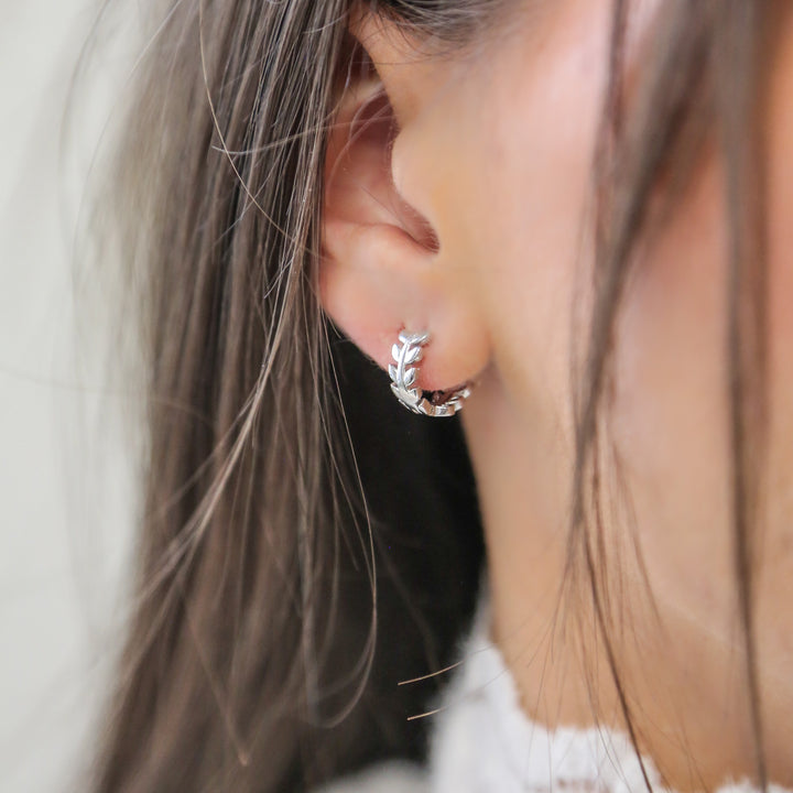 a close up of a person wearing a pair of earrings