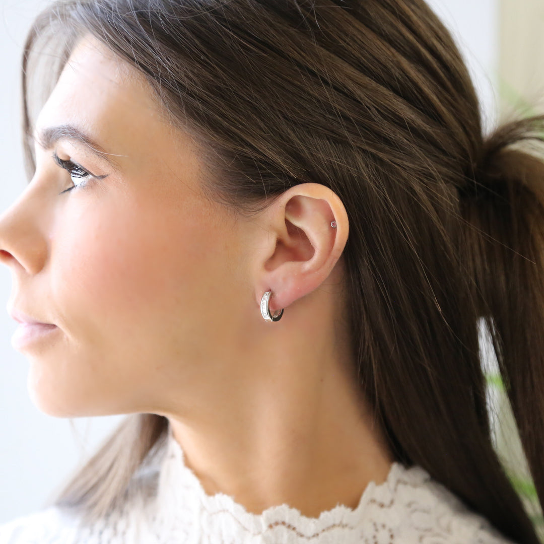 a close up of a person wearing a pair of earrings