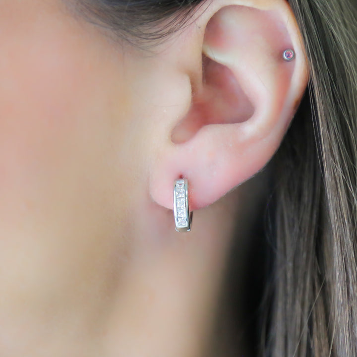 a close up of a person wearing a pair of earrings