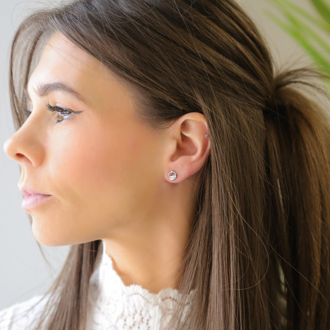 a woman with long hair wearing a pair of earrings