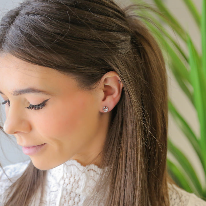 a woman with long hair wearing a pair of earrings