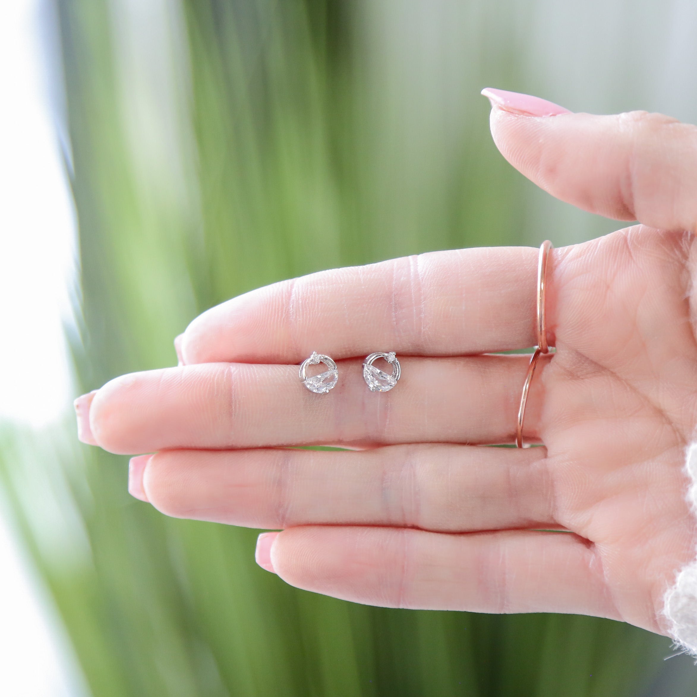 a woman's hand holding a tiny diamond ring