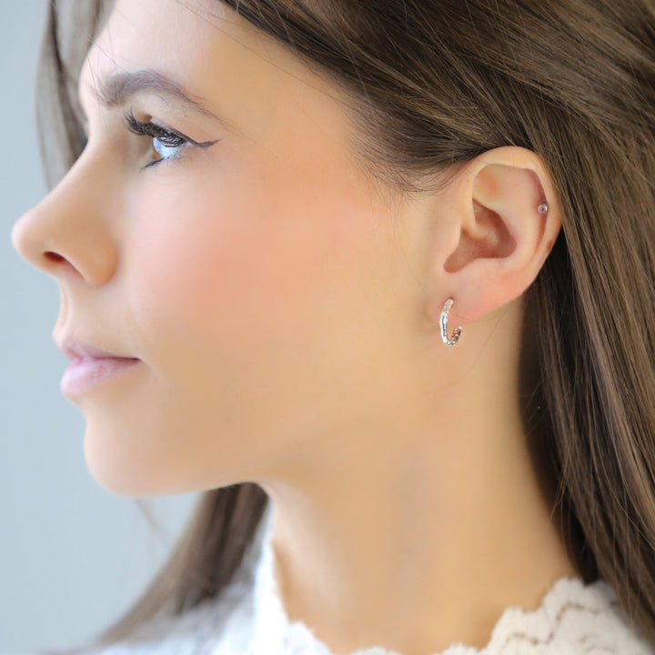 a close up of a person wearing a pair of earrings