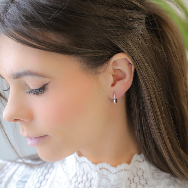 a close up of a person wearing a pair of earrings