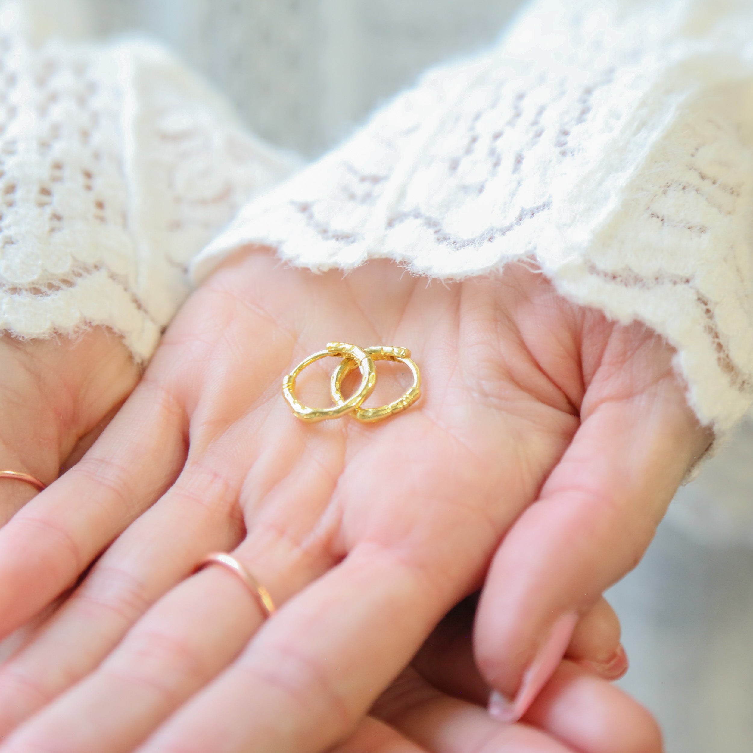 a person holding a pair of wedding rings in their hands