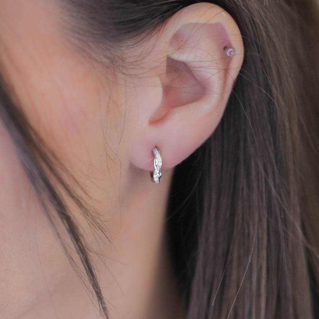 a close up of a person wearing a pair of earrings