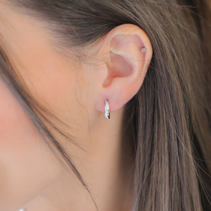 a close up of a person wearing a pair of earrings