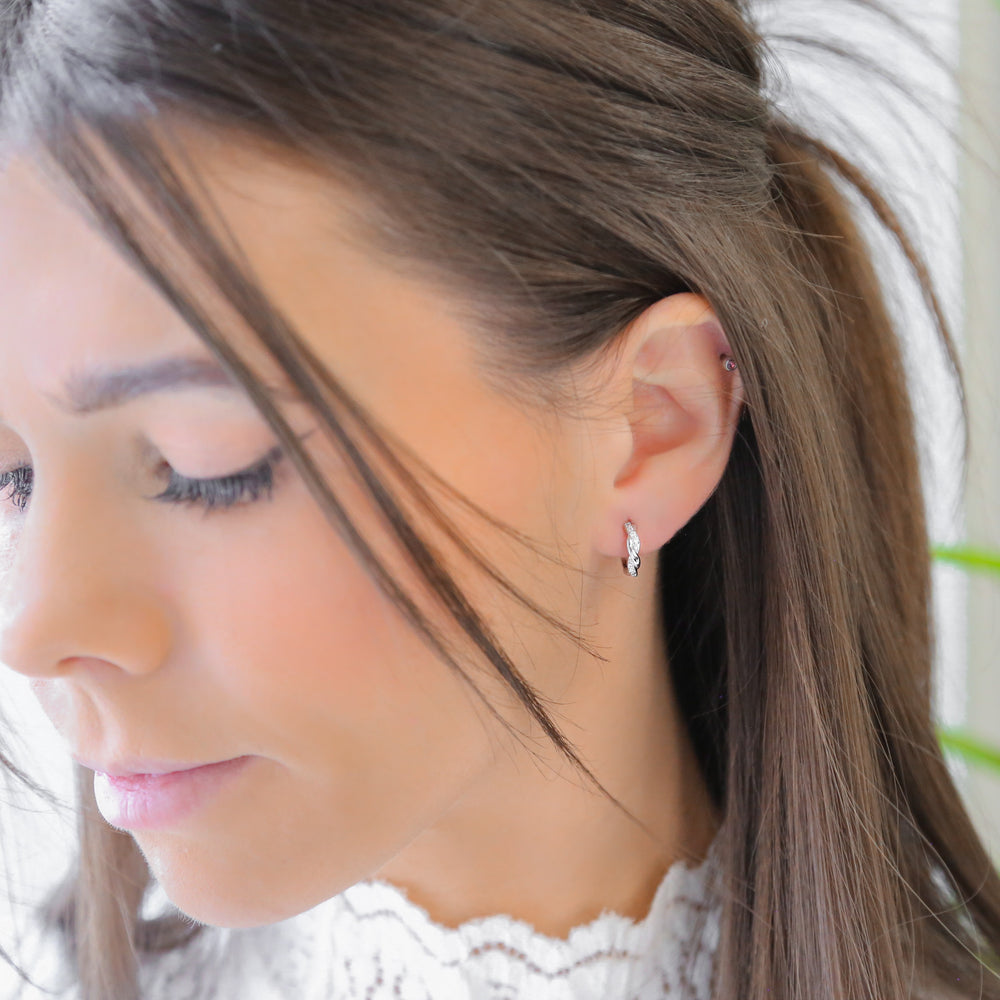 a close up of a person wearing a pair of earrings