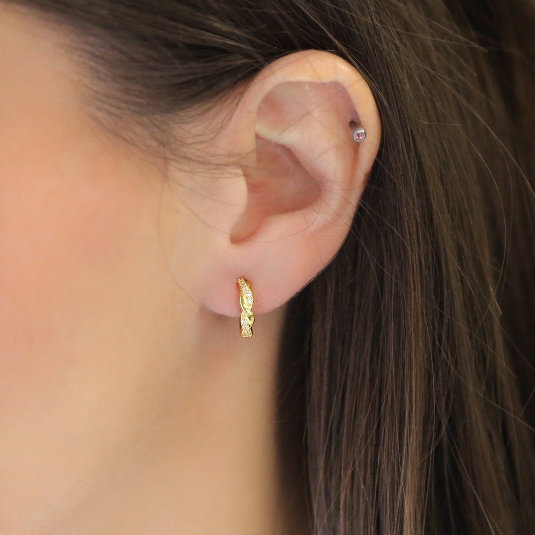 a close up of a person wearing a pair of earrings