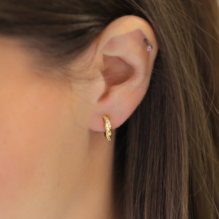 a close up of a person wearing a pair of earrings