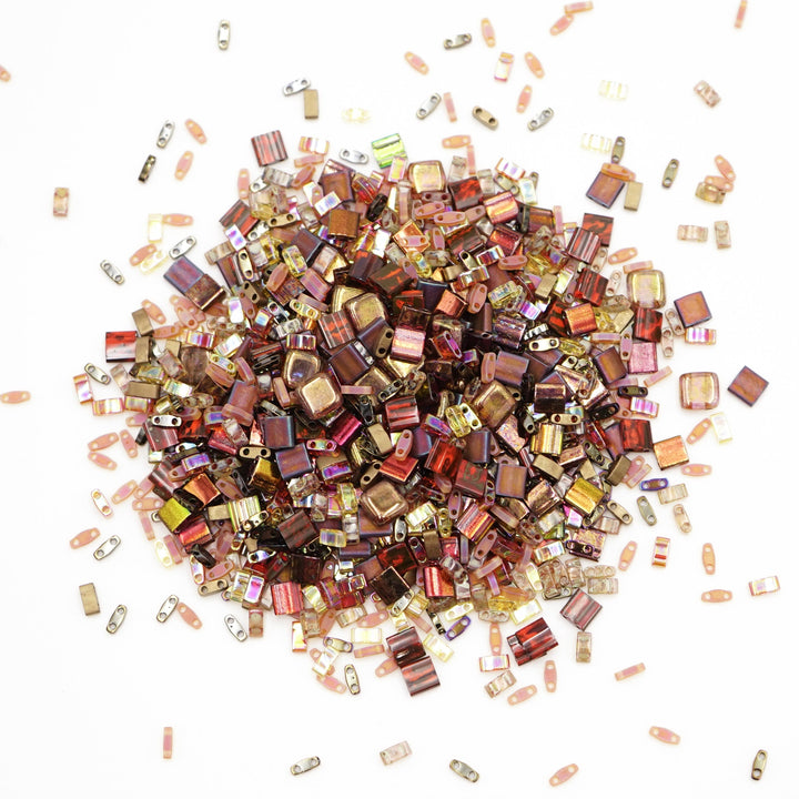 a pile of assorted colored beads on a white surface