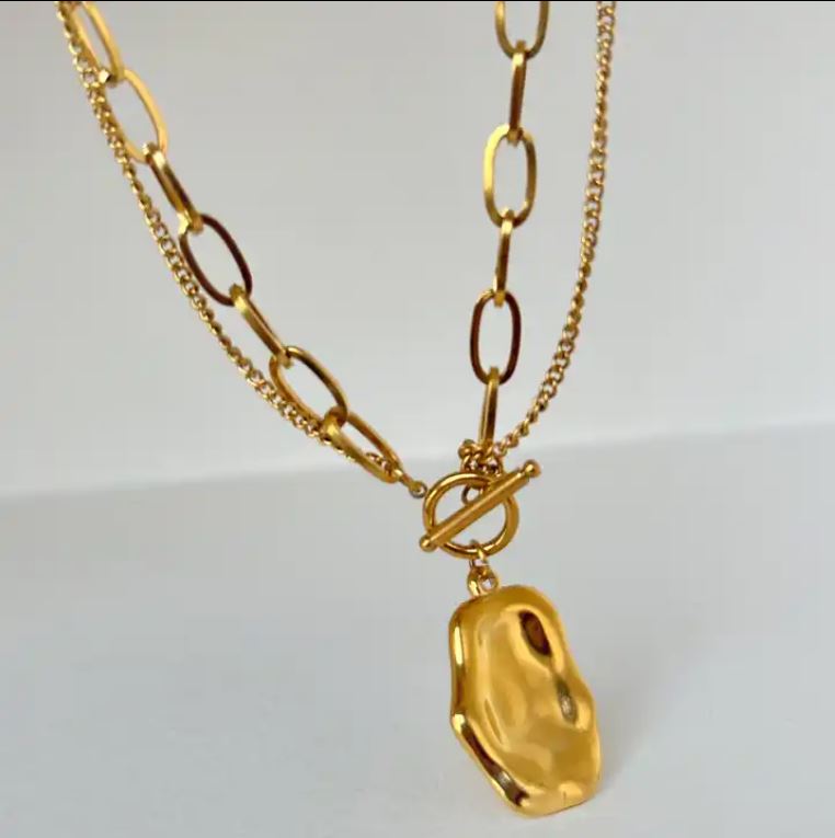 a gold plated necklace with a pendant hanging from it