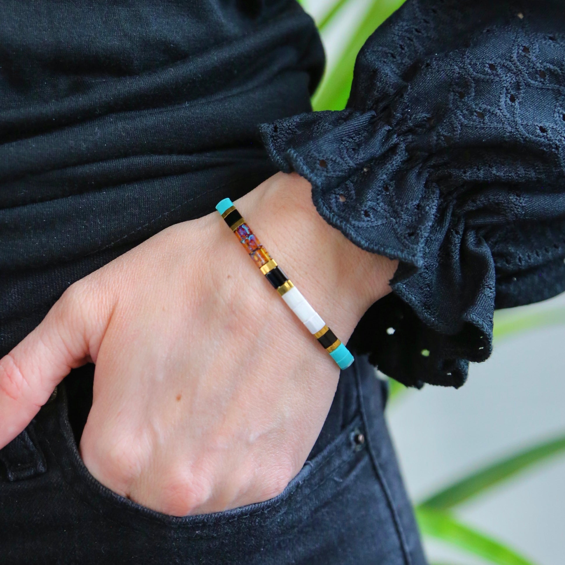 a person wearing a bracelet with a colorful bead