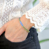 a woman wearing a blue and green bracelet