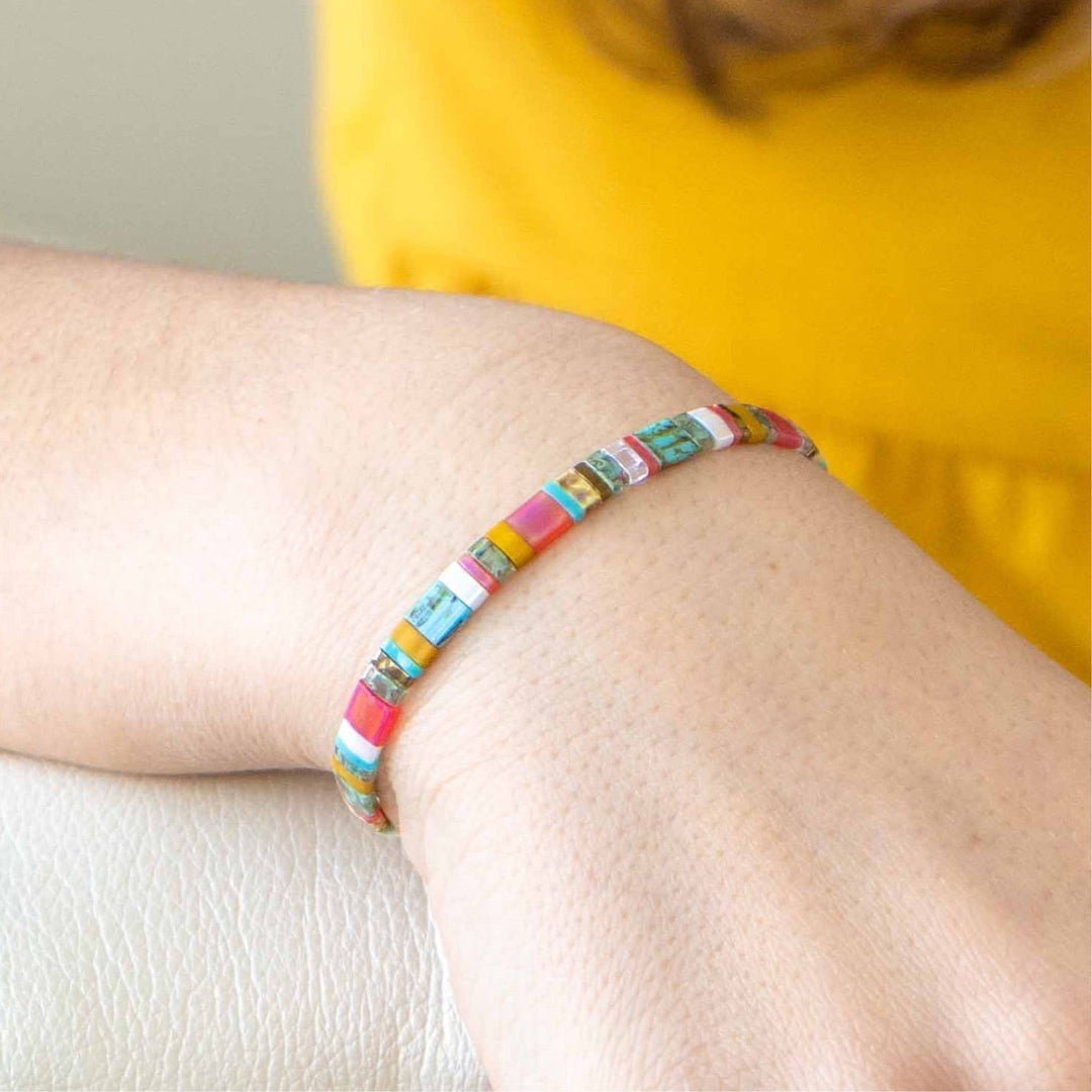 a woman wearing a bracelet with colorful beads